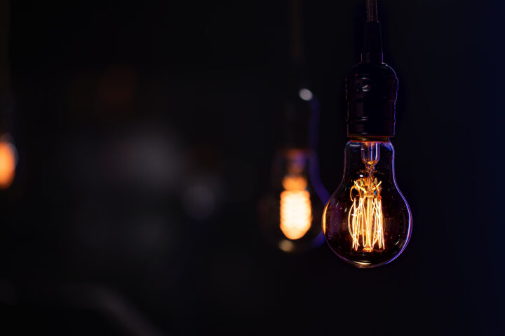 burning lamp hangs dark blurred background | Lumen Kinnisvarabüroo